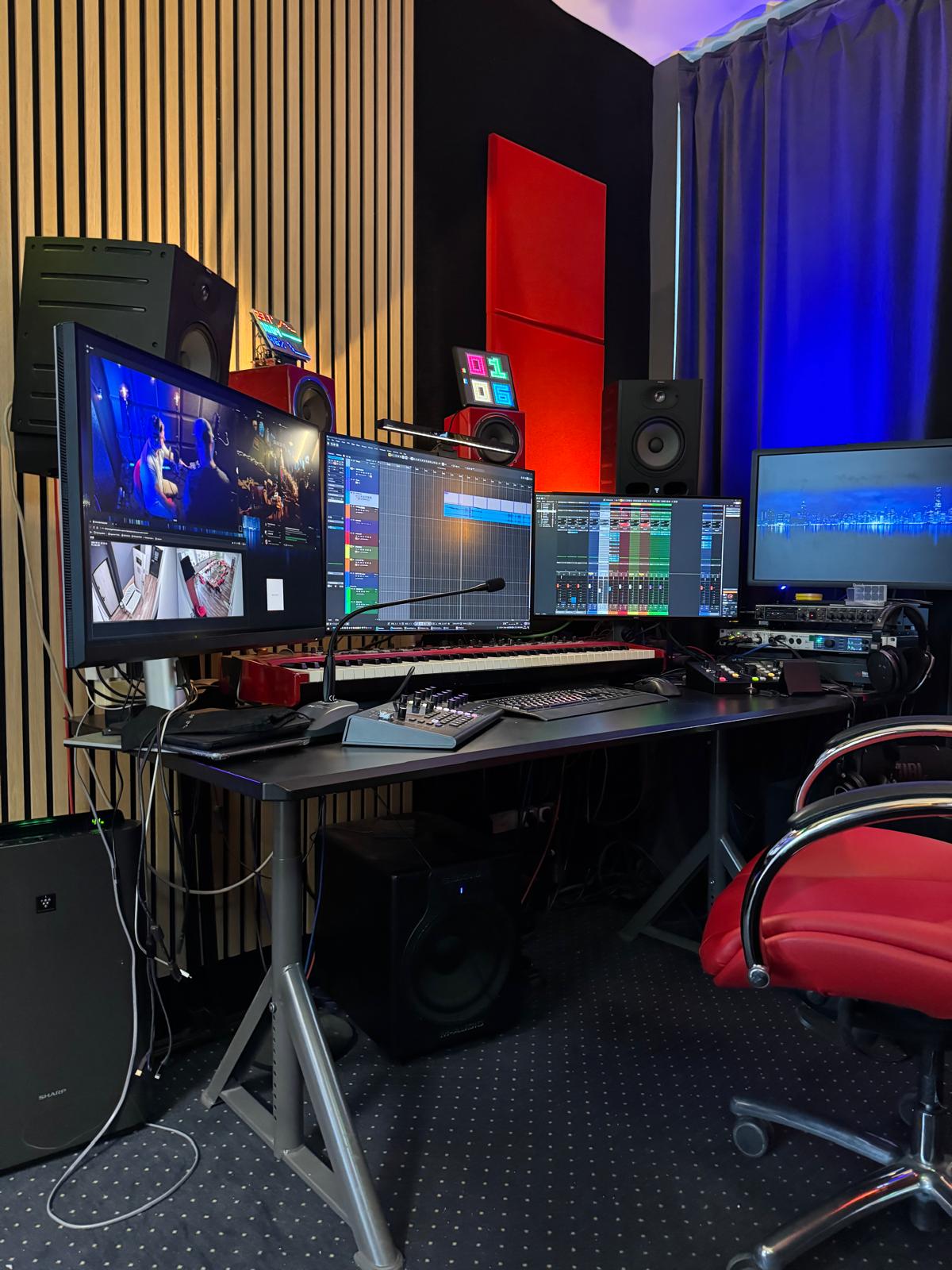 Studio postprodukcji - biurko z monitorami, klawiaturą MIDI i odsłuchami w wygłuszonym pokoju